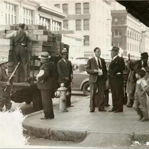 [Men unloading a produce truck under armed guard during the general strike of 1934]