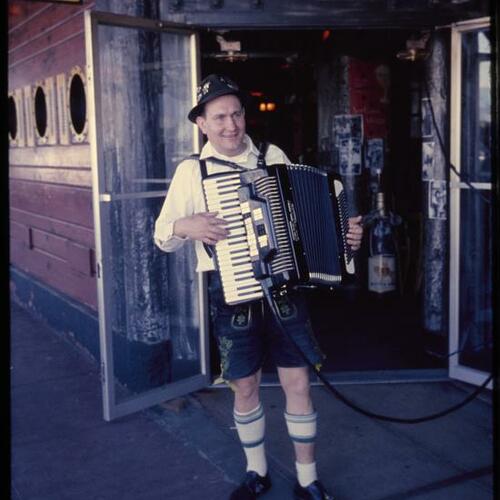 Person in playing accordion outside restaurant