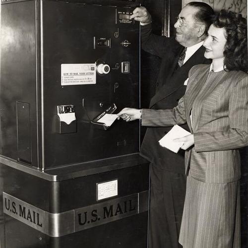 [Postmaster William McCarthy is assisted by Sharon Dralle while demonstrating the new Mailomat]