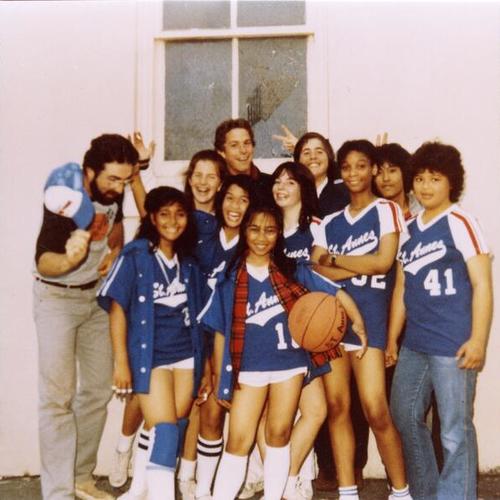 [St. Anne girls basketball team and Holly standing with knee brace next to instructor]
