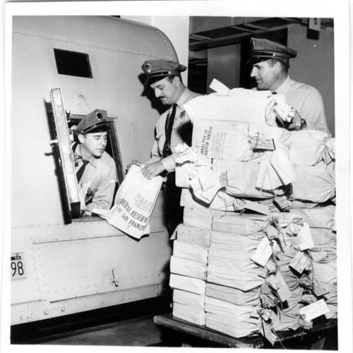 [Loomis Armored Car Service employees Frank Soto, John Leone and Nick Dentici loading money into a truck at the Federal Reserve Bank of San Francisco]