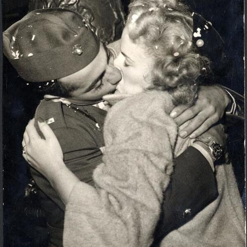 [Marine lieutenant and girl kissing after hearing the news of Japan's surrender]