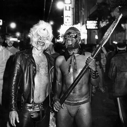 [Two men dressed in costumes partaking in Halloween festivities on Castro street]