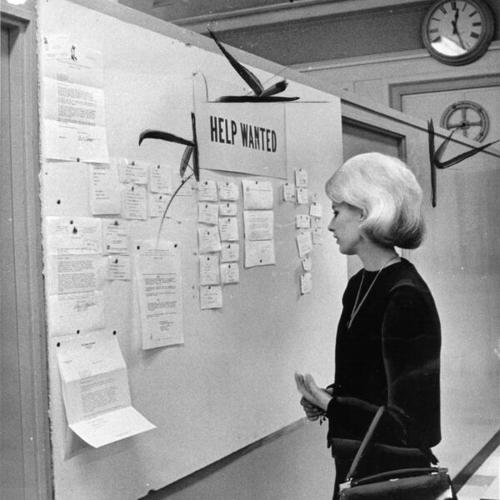 [White House department store employee Barbara Kimsjo checking job listings on a bulletin board at the store]