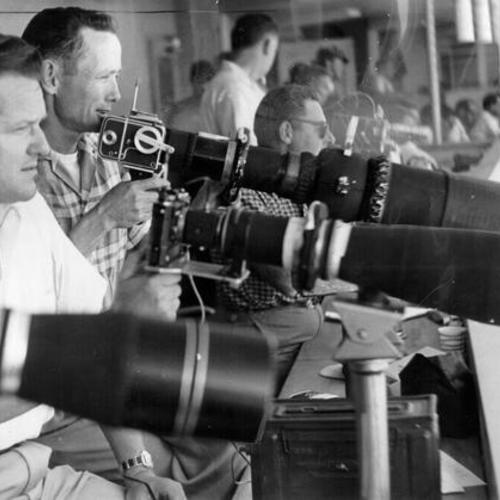 [Newspaper photographers aiming their cameras on Candlestick Park's field]