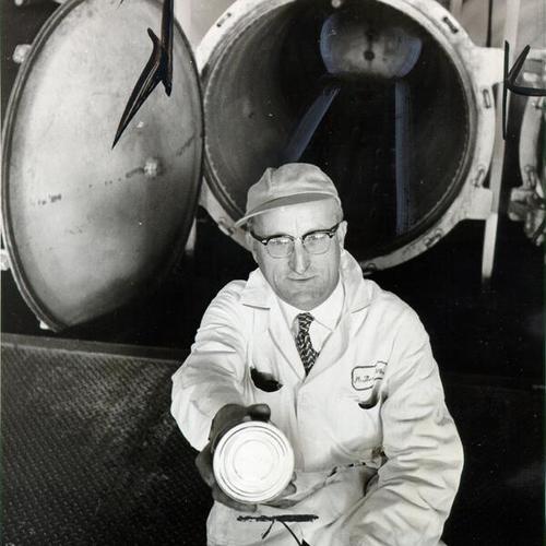 [Plant supervisor Thomas Miller standing in front of high-pressure cookers at the Washington Packing Corporation cannery after plant operations were suspended when to two cans of tuna produced there were found to be tainted with botulism]