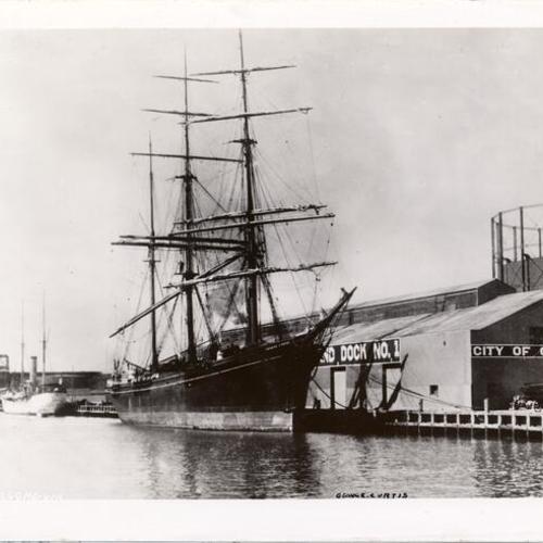 [Sailing ship "George Curtis" docked in Oakland with steamship "Algonquin" in background]