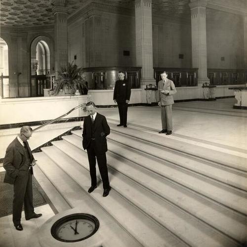 [Four men standing in the lobby of Crocker First National Bank]