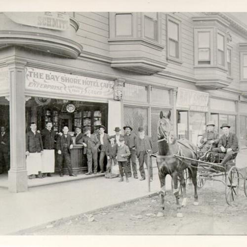 [Group of people posing outside of the Bay Shore Hotel Cafe in Visitacion Valley]