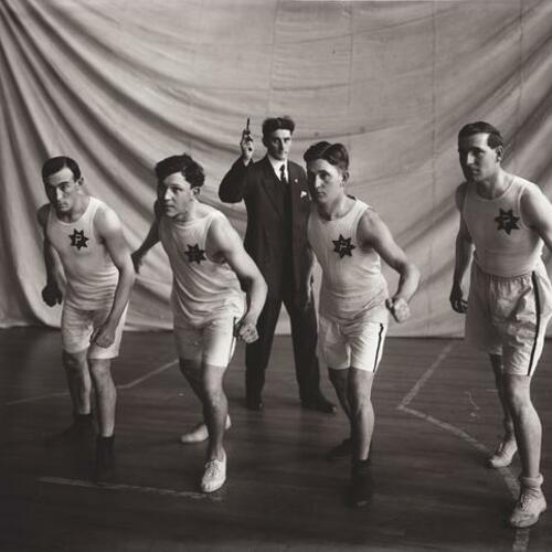 Portrait of five people in racing pose in gymnasium
