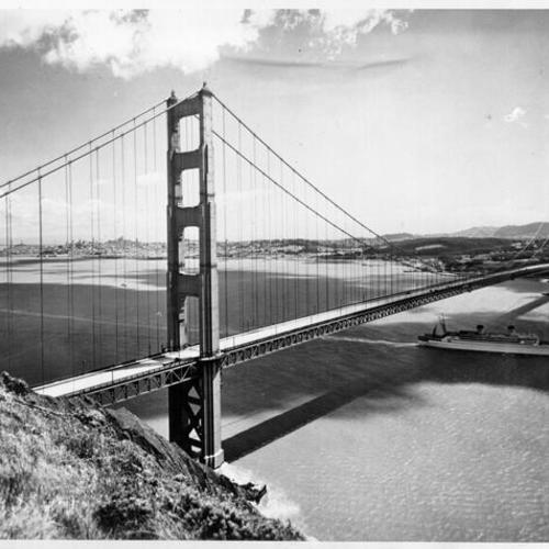 [View of the Golden Gate Bridge from the Marin County side, showing a ship passing underneath the bridge and San Francisco in the distance]