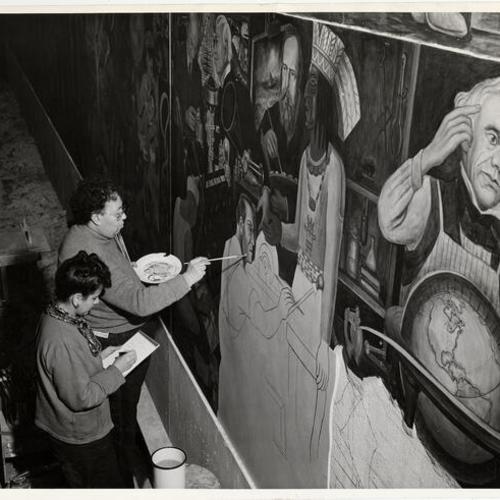 [Diego Rivera putting finishing touches on fresco with assistant Enda Wolff]