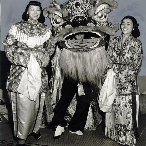 [Martha Fong and Dorothy Lew standing next to the lion, Lim Dor, in the Triple Seven parade]