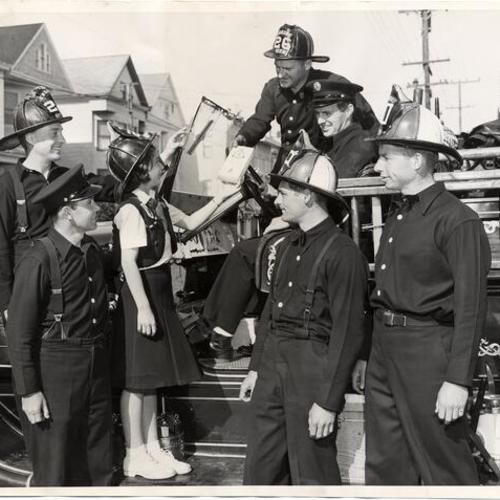 [Grace Melbern from San Francisco Camp Fire Girls Council selling mints to firemen at Fire Engine 26]