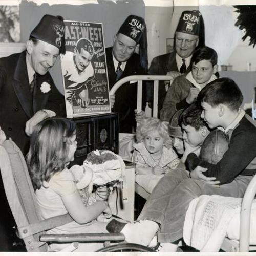 [Shriners Al Hammergren, William Poyner and Herm Wertsch visiting patients at the Shriners' Hospital for Crippled Children]