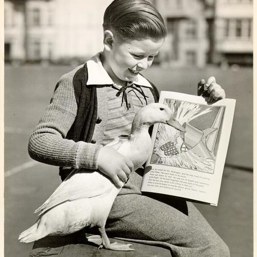 [McCoppin School student Mervyn Lyons posing with his pet duck, "Duckie"]