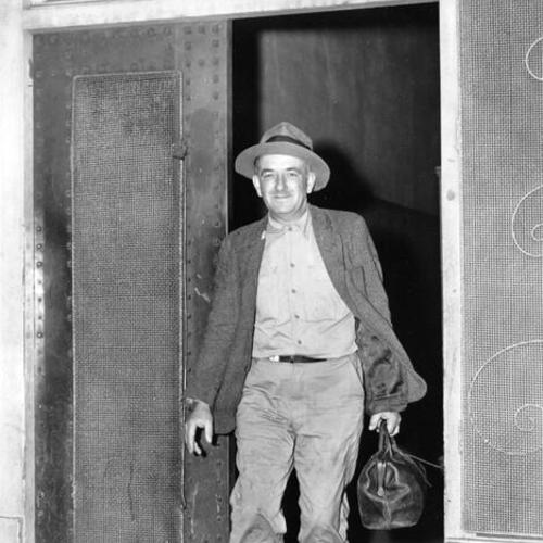 [Eighteen year resident Frank Joseph Clancey leaving the New York House hotel for the last time]