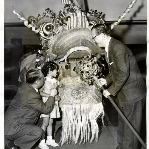 [Charmaine Wong standing in front of a 250-foot long dragon with her father Albert Wong]