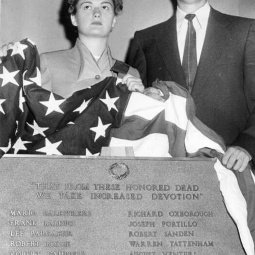 [Janell Simmons and Douglas McLendon unveiling a plaque dedicated to Lincoln High School students killed in the Korean war]