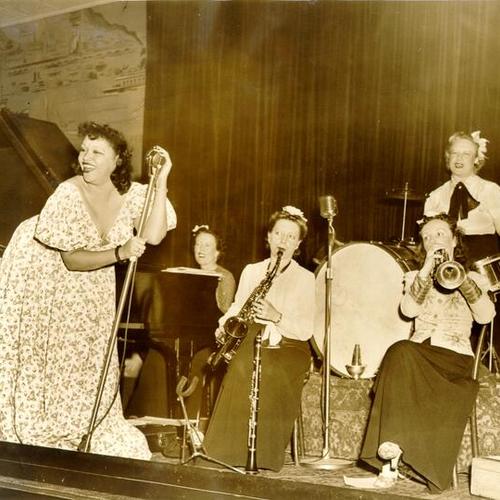 [Caroline Snowden on stage with Lenore O'Neil and her "ladies of rhythm" at the Backstage nightclub]