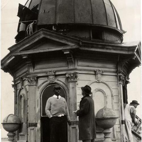 [C. A. Harris, deacon of the Third Baptist Church, talking to a News reporter on the roof of the former mansion of Captain Charles Goodall at Pierce and McAllister streets]