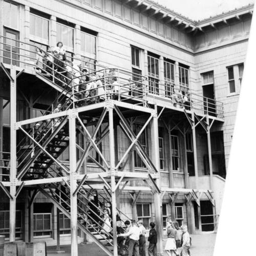 [Children walking up a fire escape after recess at Starr King Elementary]