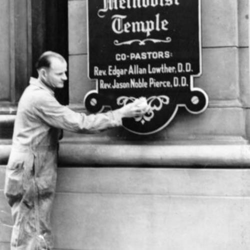 [Unidentified man cleaning sign on front of First Congregational Church]