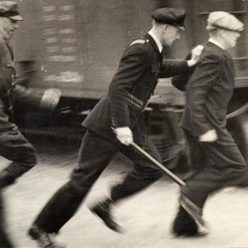 [Two police officers chasing a man during the longshoremen's strike of 1934]