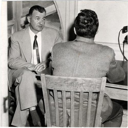 [Inspector John Curtin conferring with a witness in the interrogation room in Old Hall of Justice]