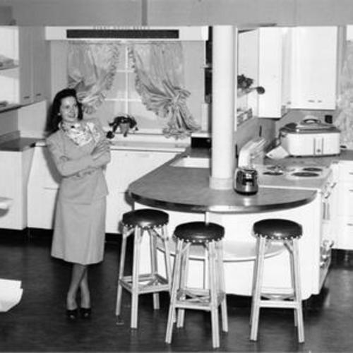 [Mary Beth Seaborn standing in a display kitchen at the Western Merchandise Mart]