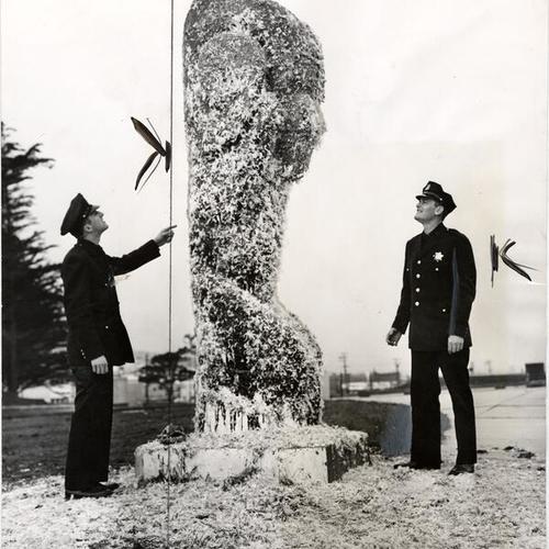 [James Dykstra and a fellow police officer inspecting a vandalized statue at City College of San Francisco]