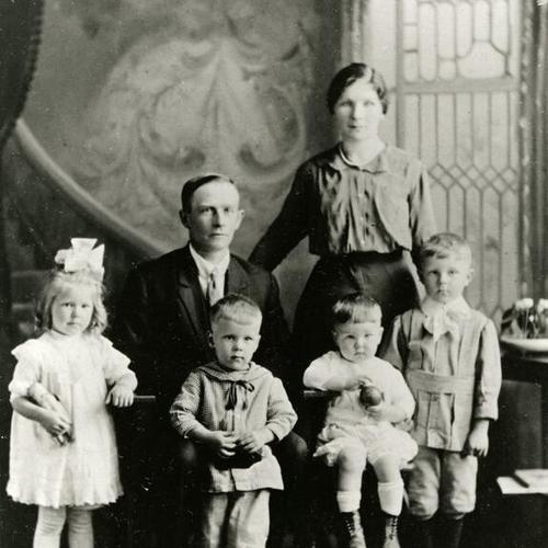 [Family posing for a studio portrait in 1920]