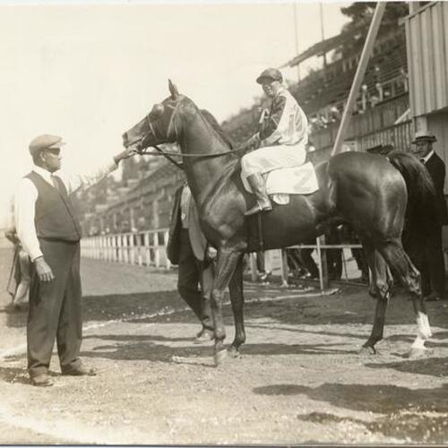 [Jockey T. T. Burns on "Acumen" during horse race at the Panama-Pacific International Exposition]