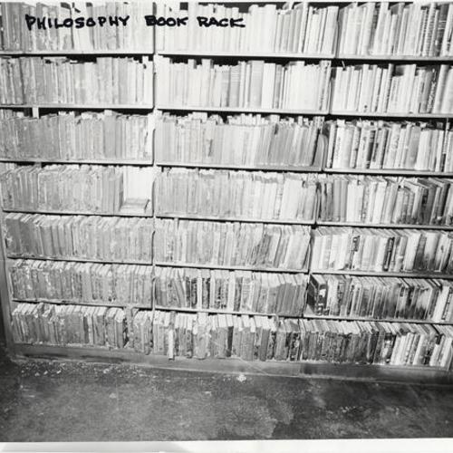 [Interior of Ortega Branch Library, showing fire and vandalism damage to philosophy book rack]
