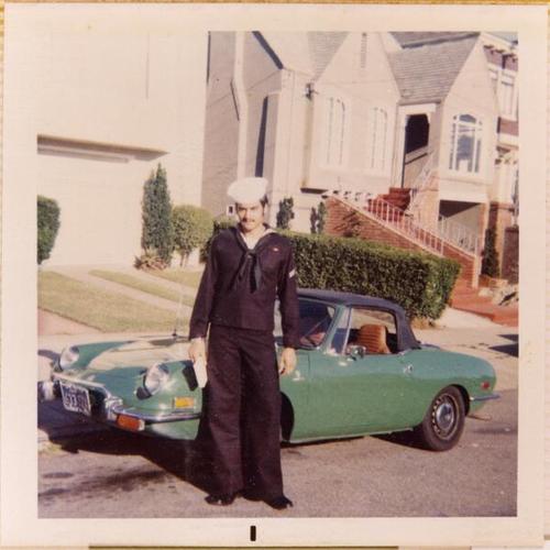[Joseph standing in front of his first car in Navy uniform before being drafted for the Vietnam War]