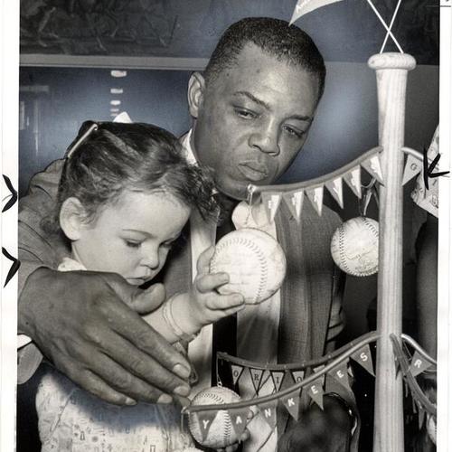 [Willie Mays showing his baseball Christmas tree to 2 year old Lorie Ann at the Children's Hospital of the East bay]
