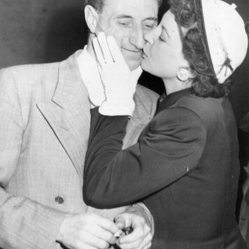 [Harry Bridges receiving a kiss from his wife]