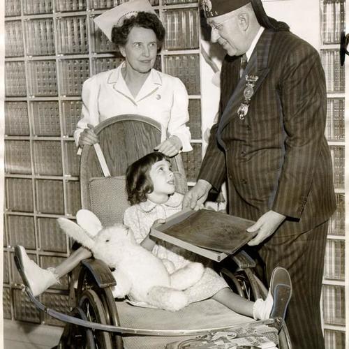 [Representative of the Shriners accepting a gift from the patients of the Shriners' Hospital for Crippled Children]