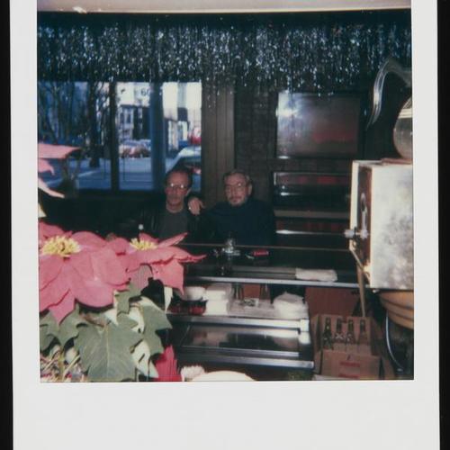 View from behind bar, with poinsettia and two people seated