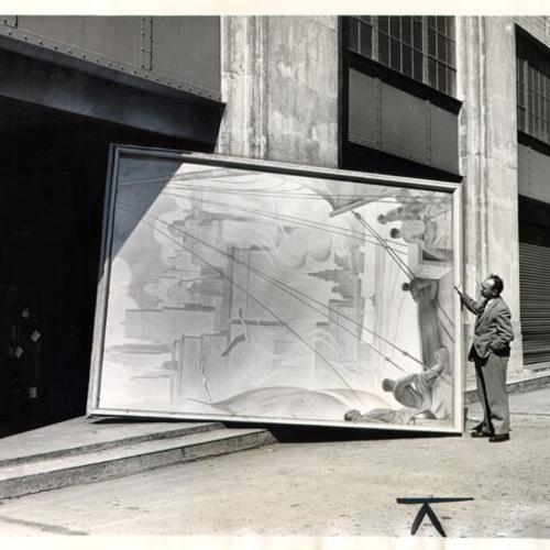 [City art surveyor Martin Snipper standing with a panel from a mural by Peter Ilyin at the city warehouse]