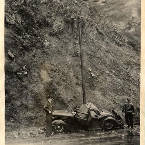 [Police officers Robert Unruh and John Brymner inspecting a car damaged by a Telegraph Hill rock slide]