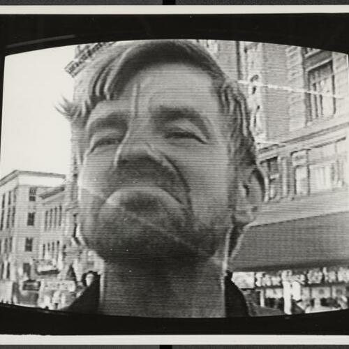 Television screen showing "David" standing in Tenderloin Street