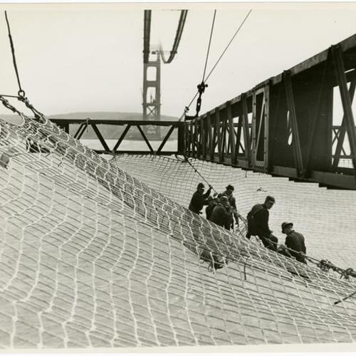 [Golden Gate Bridge construction workers standing in a safety net]