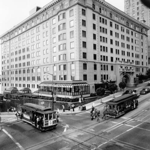 [Two cable cars crossing outside the Stanford Court Hotel, California and Powell streets]