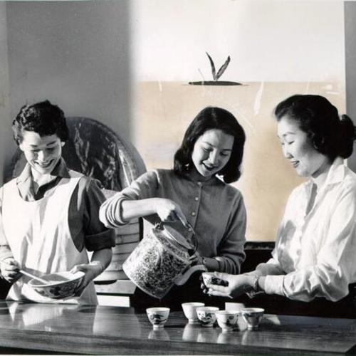 [Three women in the kitchen cooking]