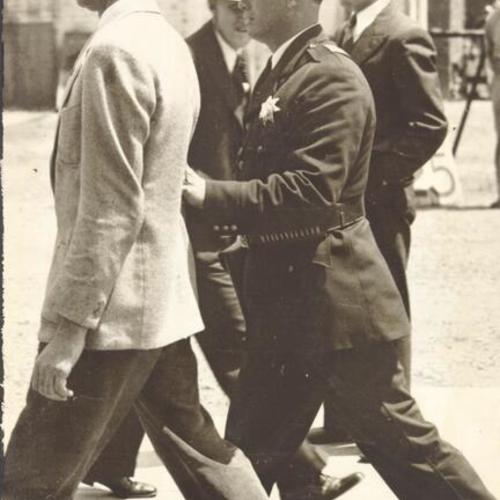 [Police officer arresting man during strike of 1934]