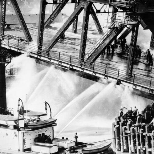 [Fire fighters and fire boat extinguishing fire on Third street bridge]