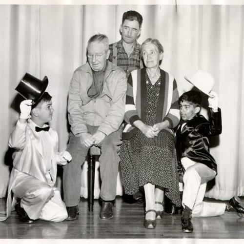 [Two young performers rehearsing for an all-children minstrel show at Laguna Honda Home, while three patients from the home watch]