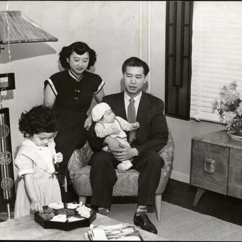 [Mr. and Mrs. Henry Wong sitting with their two children in one of Ping Yuen's display apartments]