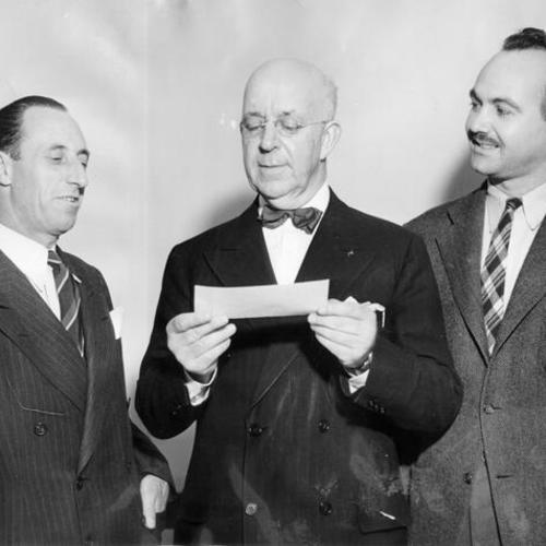 [Harry Bridges (left) and Don R. Healey, present a check to Charles R. Page, treasurer of the San Francisco War Chest]